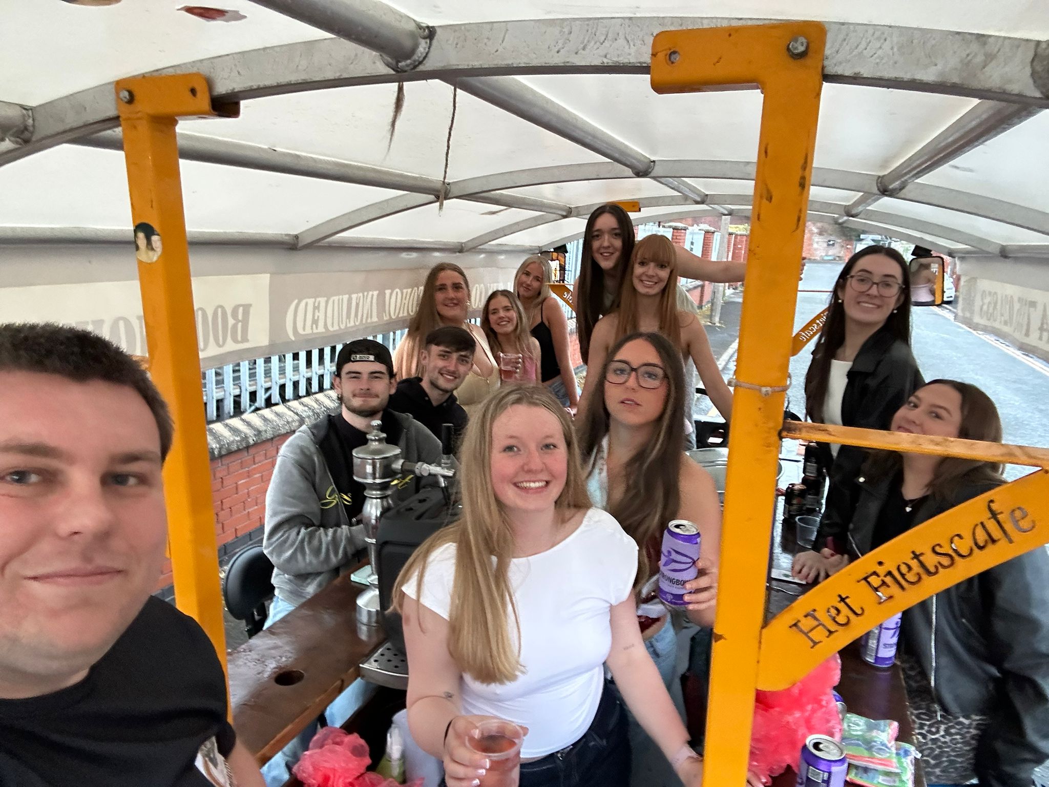 A student group laughing with drinks on board the PedalCity party bike